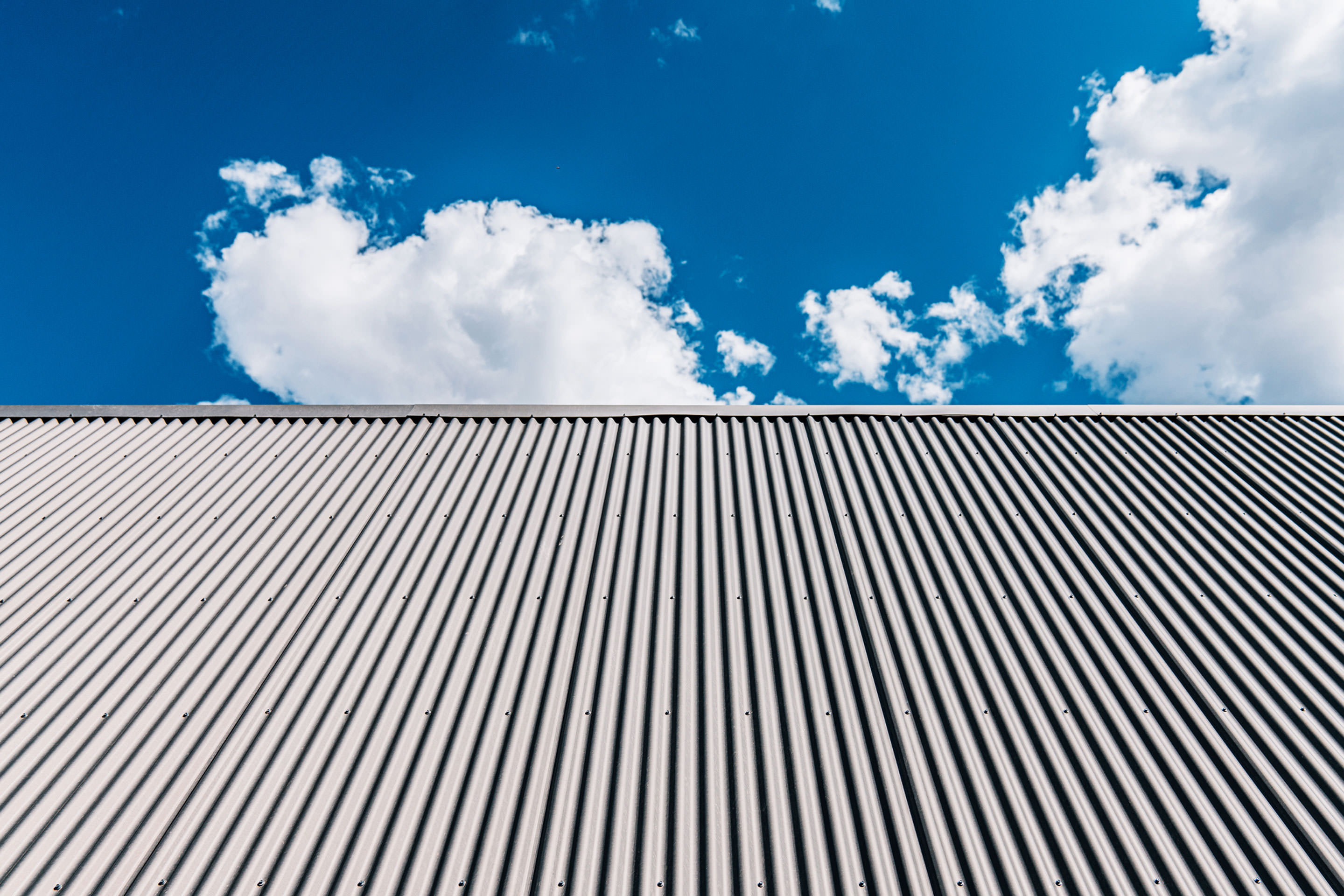 Blue sky above tall office building exterior.