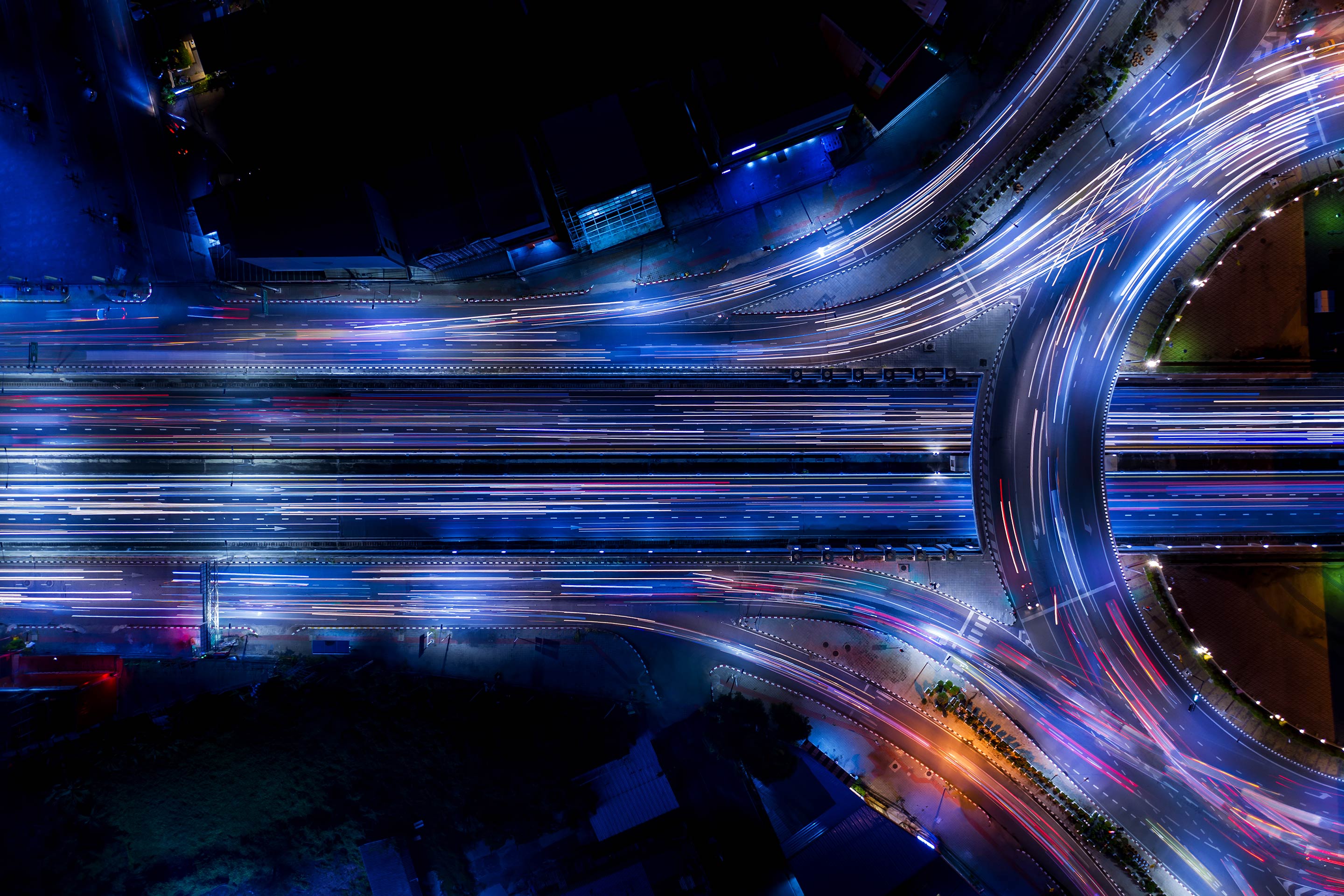 From above, cars speeding along interconnecting highways resemble the flow of data building an ecosystem