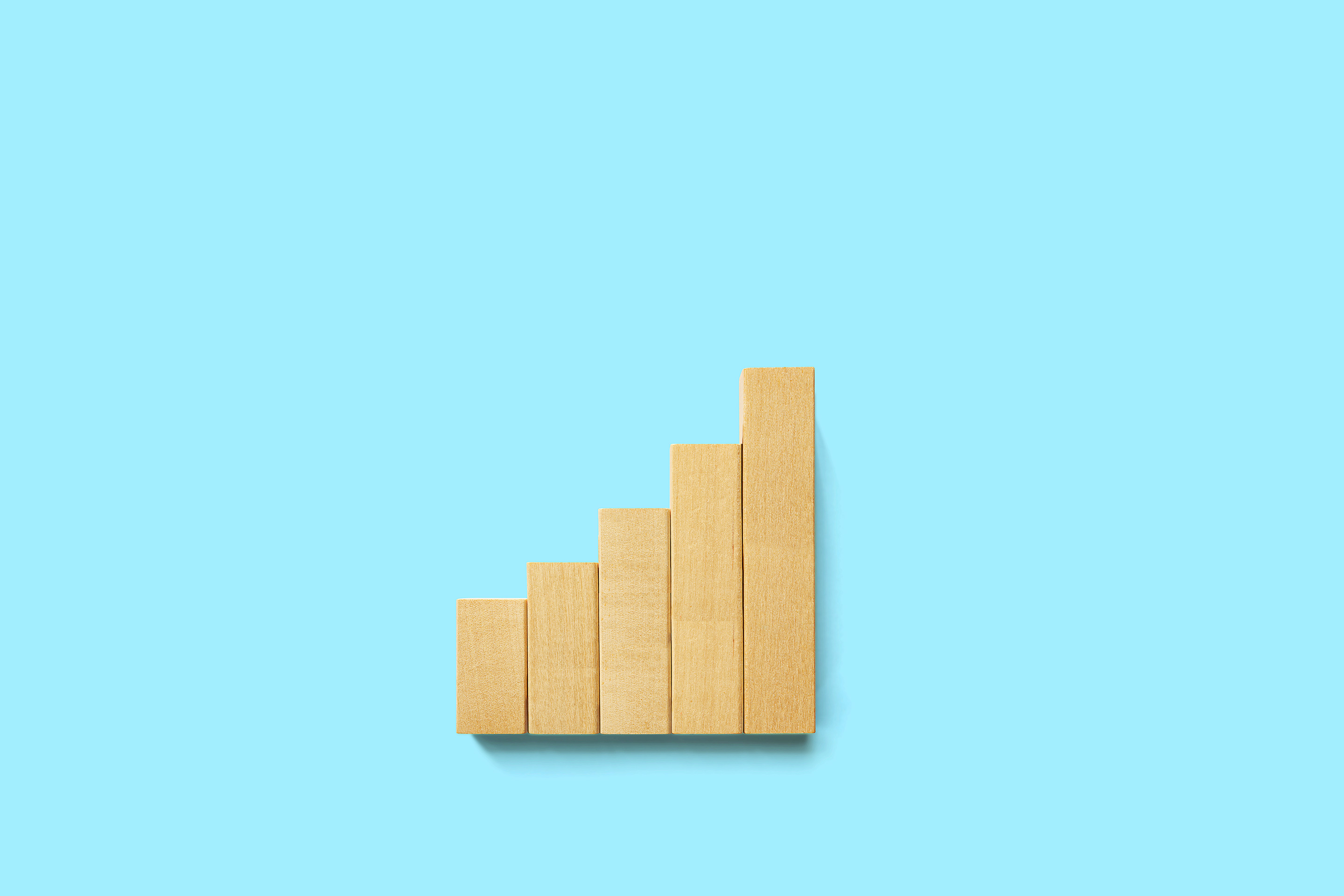 Five wooden blocks in ascending order on a blue background, representing potential portfolio performance