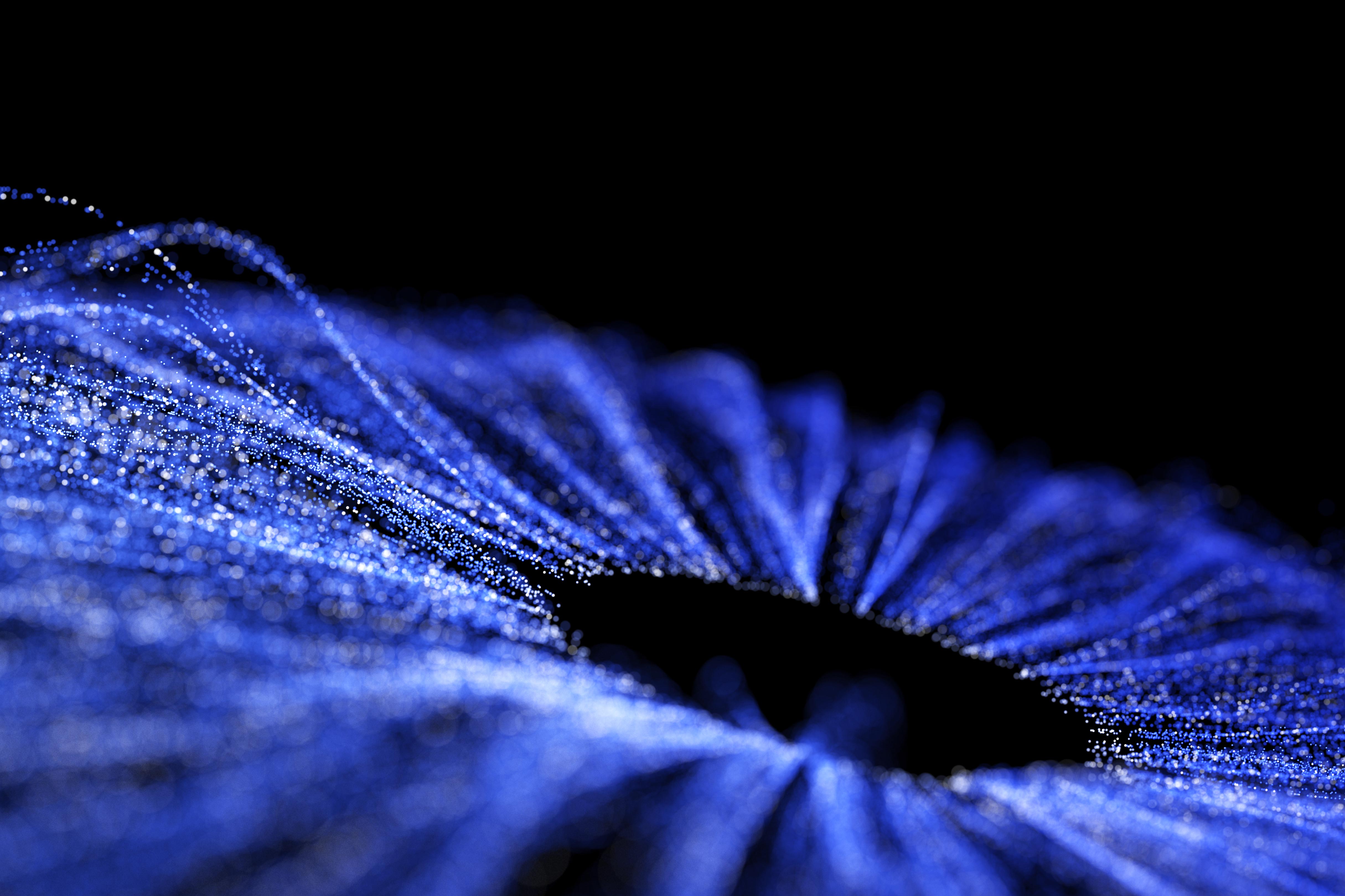 Blue threads of particles on a black background come together to form a circle of negative space, representing connectivity.