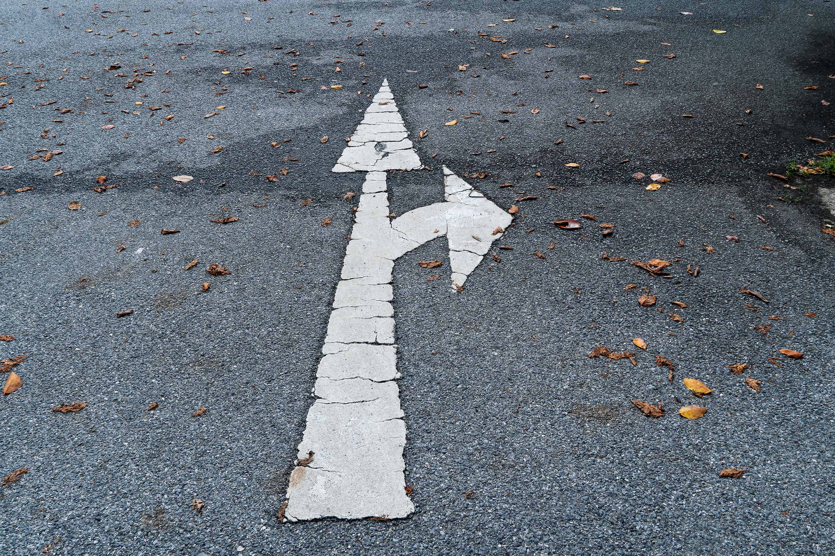 An image of a road with arrows pointing ahead and to the right, as a metaphor for considering investing goals