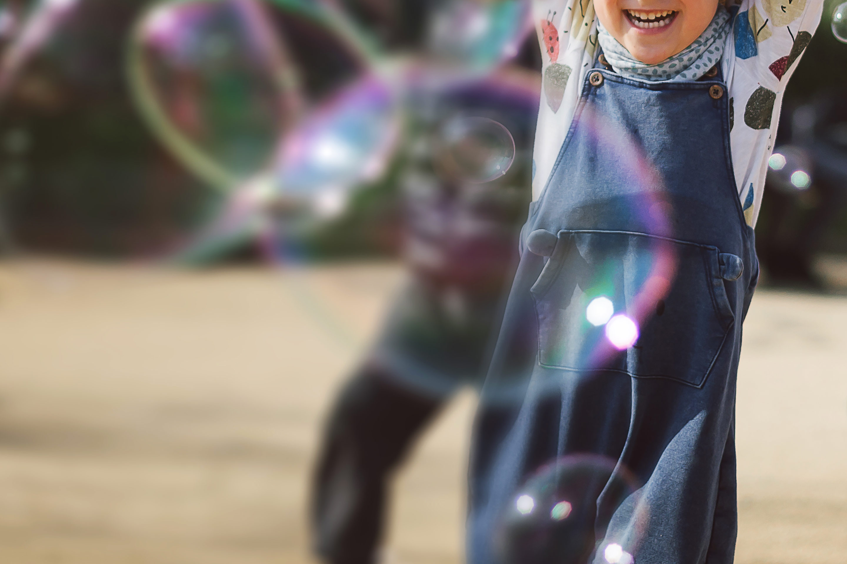 Small children having fun playing with bubbles, a reminder of what's most important about investing.
