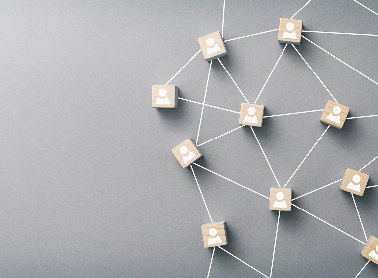 Many small wooden blocks with white figures are connected by lines creating a community.