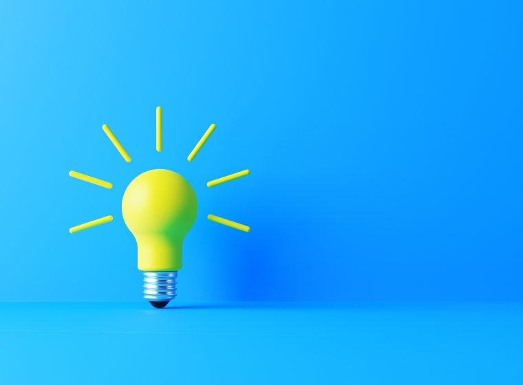 A bright yellow lightbulb radiates ideas on a blue background representing data flow