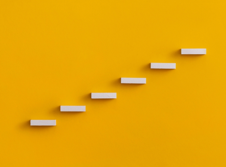 Vibrant orange background with white stairs ascending, as a representation of potential investment returns