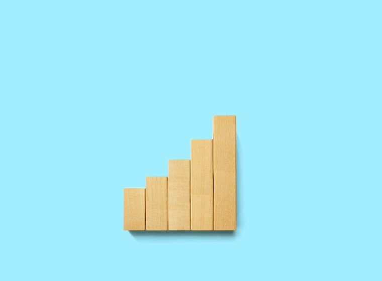 Five wooden blocks in ascending order on a blue background, representing potential portfolio performance