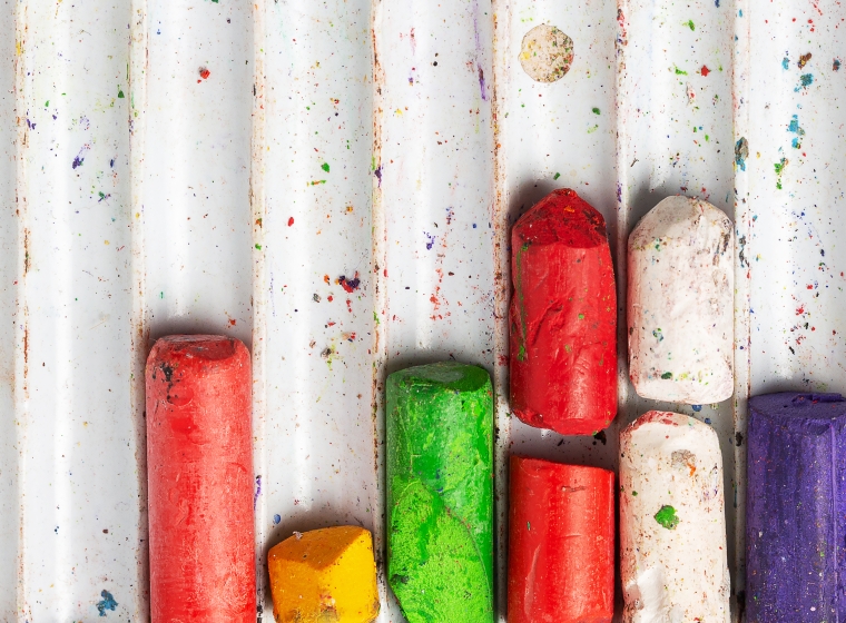 An image of different colors of chalk in a tray.