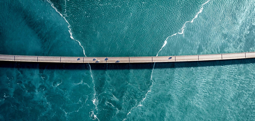 Aerial shot of bridge over water representing bridging communication..