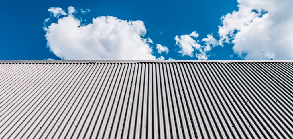 Blue sky above tall office building exterior.