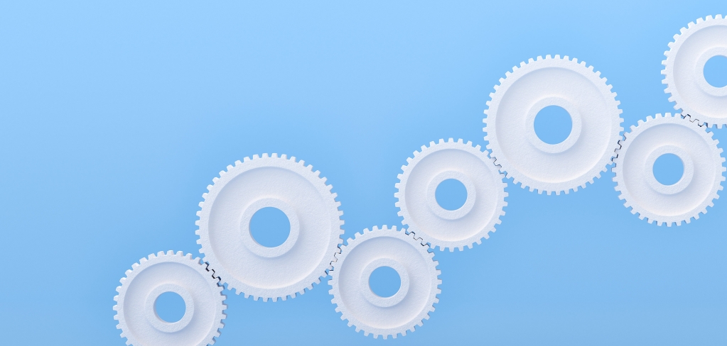 White cogs connect and grow across a blue background creating an ecosystem