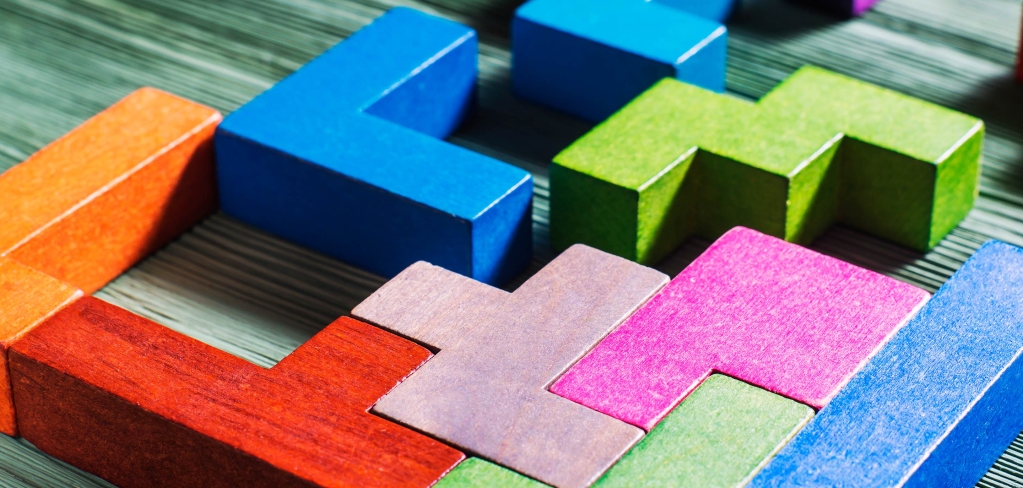 Colorful blocks of all different shapes connect together to form a solid piece, showing the value of integrating different ideas.