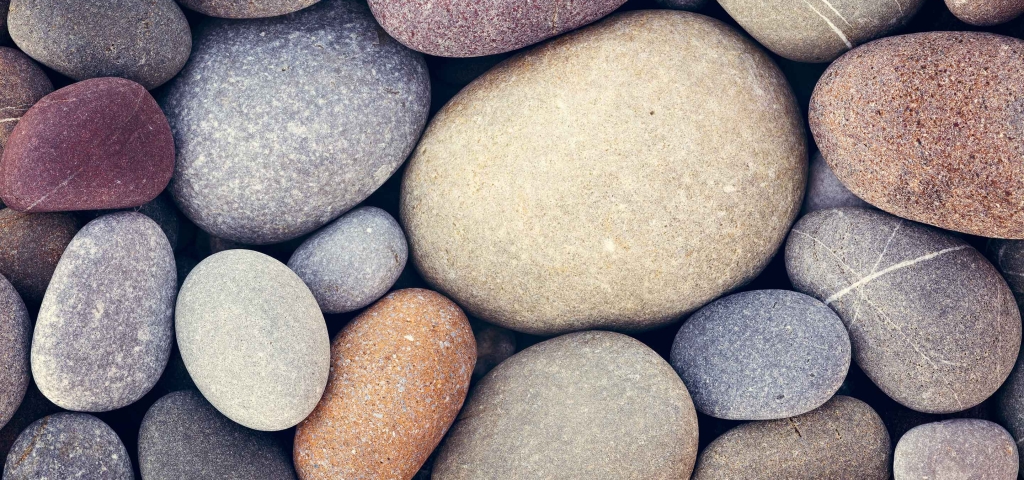 Multi-color river rocks nestled together representing communities.