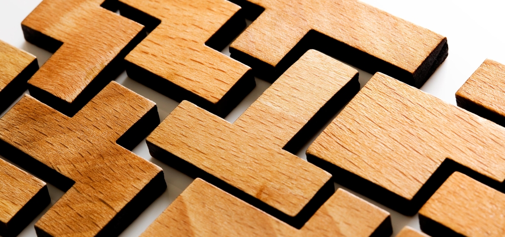 Wooden blocks are all different shapes yet come together to connect and create a solid piece.