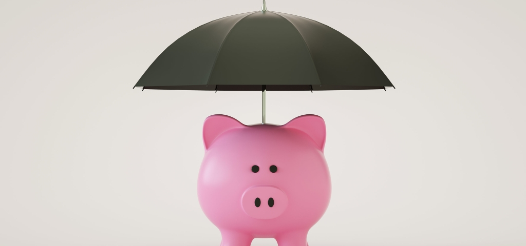 Pink piggy bank with black umbrella above it, representing retirement savings