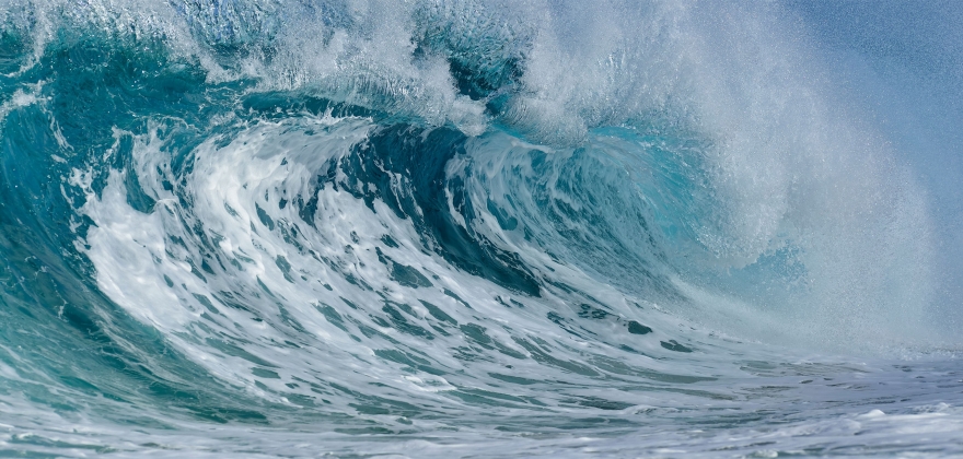 The never-ending tide. A beautiful aqua ocean wave rolls into the shore,  representing ongoing, reliable service.