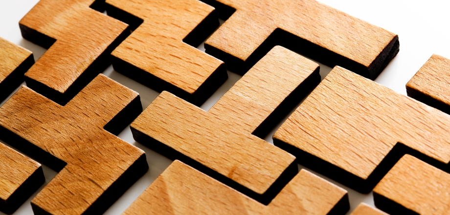 Wooden blocks are all different shapes yet come together to connect and create a solid piece.