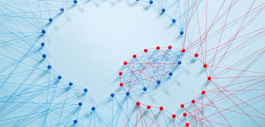 Red and blue string and pins create dialogue bubbles, showing how two groups can partner together effectively.