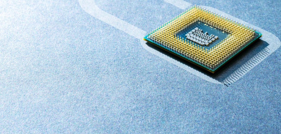 The shape of a padlock is formed from a microchip lying inside a colored outline on a pristine blue surface