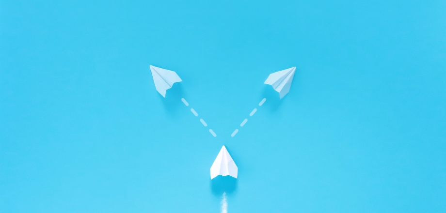 Image of white arrow on blue background, and facing a crossroad about whether to go left or right as a metaphor for considering investment decisions