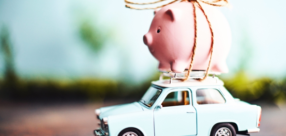 Piggy bank tied to the roof a miniature car representing retirement savings