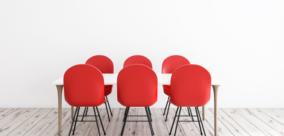 Six chaises rouges autour d'une table