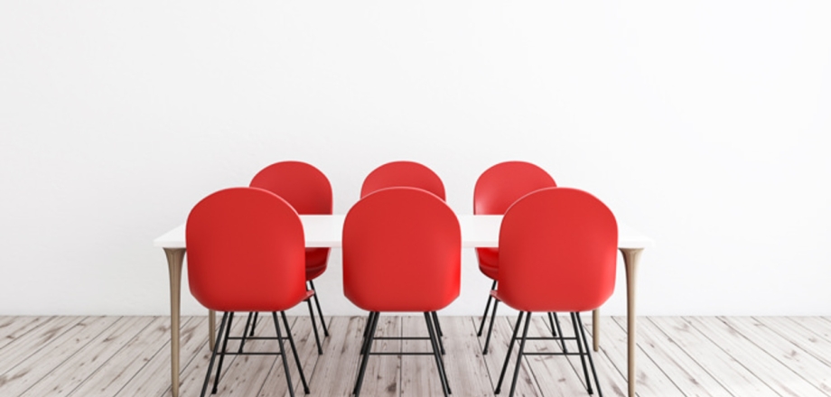 Six red chairs around a table