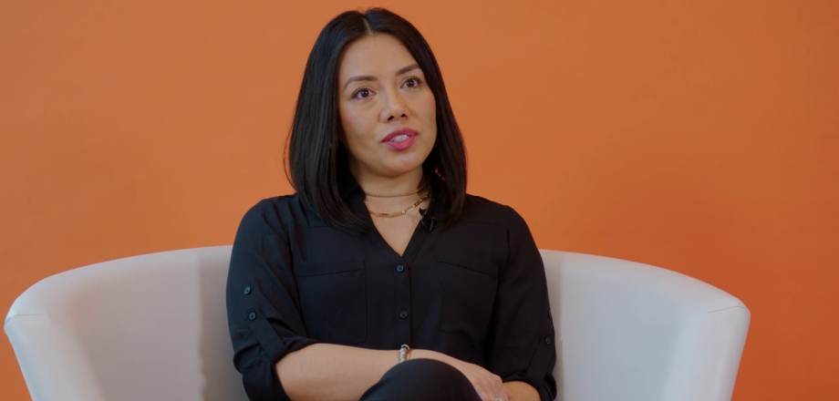 Armonia Garcia Diaz est assise sur une chaise blanche sur fond orange